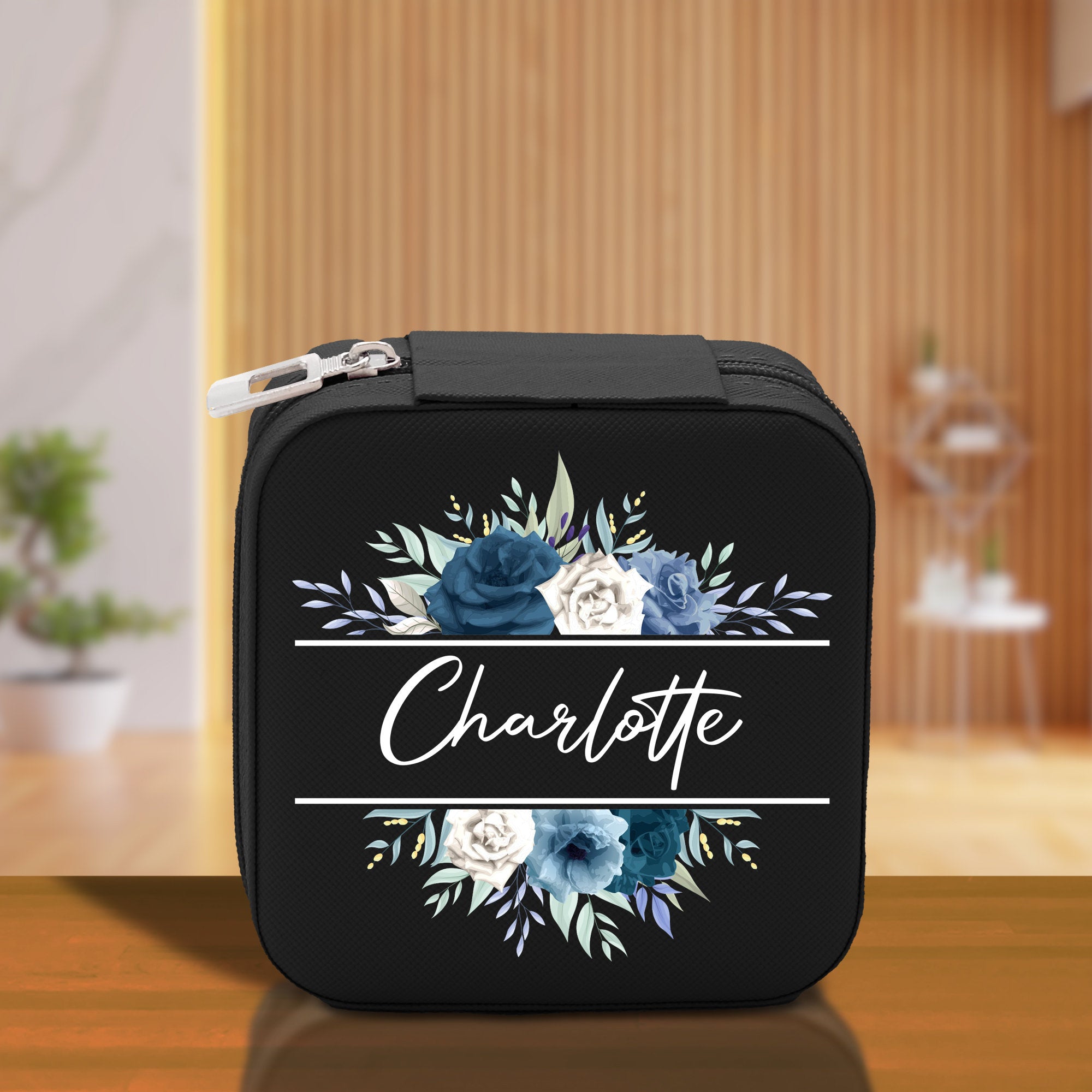 a black case with blue flowers and the word charlotte on it
