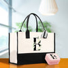 a white and black tote bag with a monogrammed f on it