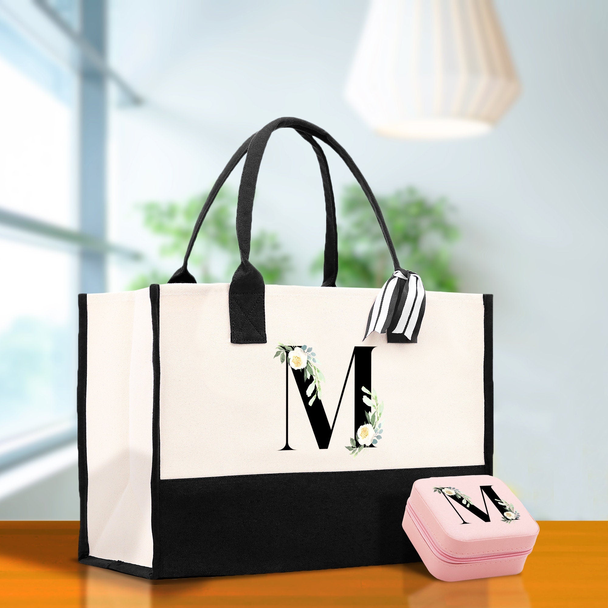 a white and black bag and a pink box on a table