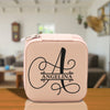 a pink lunch box with the letter a on it