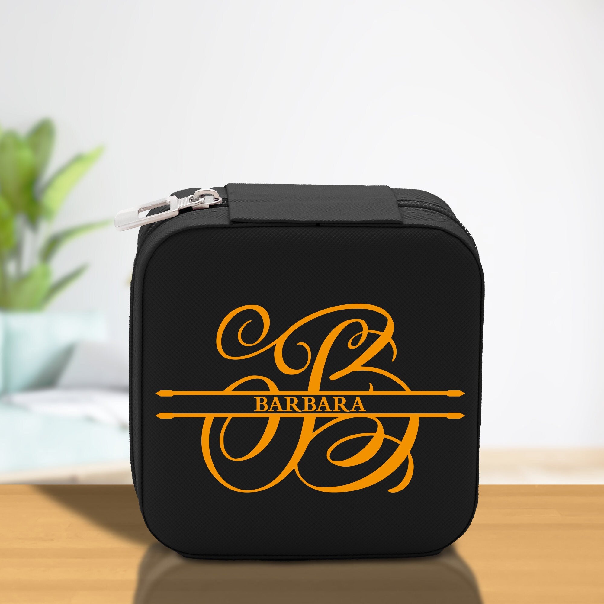 a black and yellow lunch box with a monogrammed logo