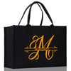 a black shopping bag with a gold m on it