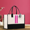 a black and white bag with a pink stripe on it