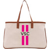 a white bag with pink stripes and a brown handle