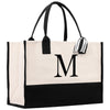 a black and white tote bag with the letter m on it