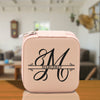 a pink lunch box with a monogrammed m on it