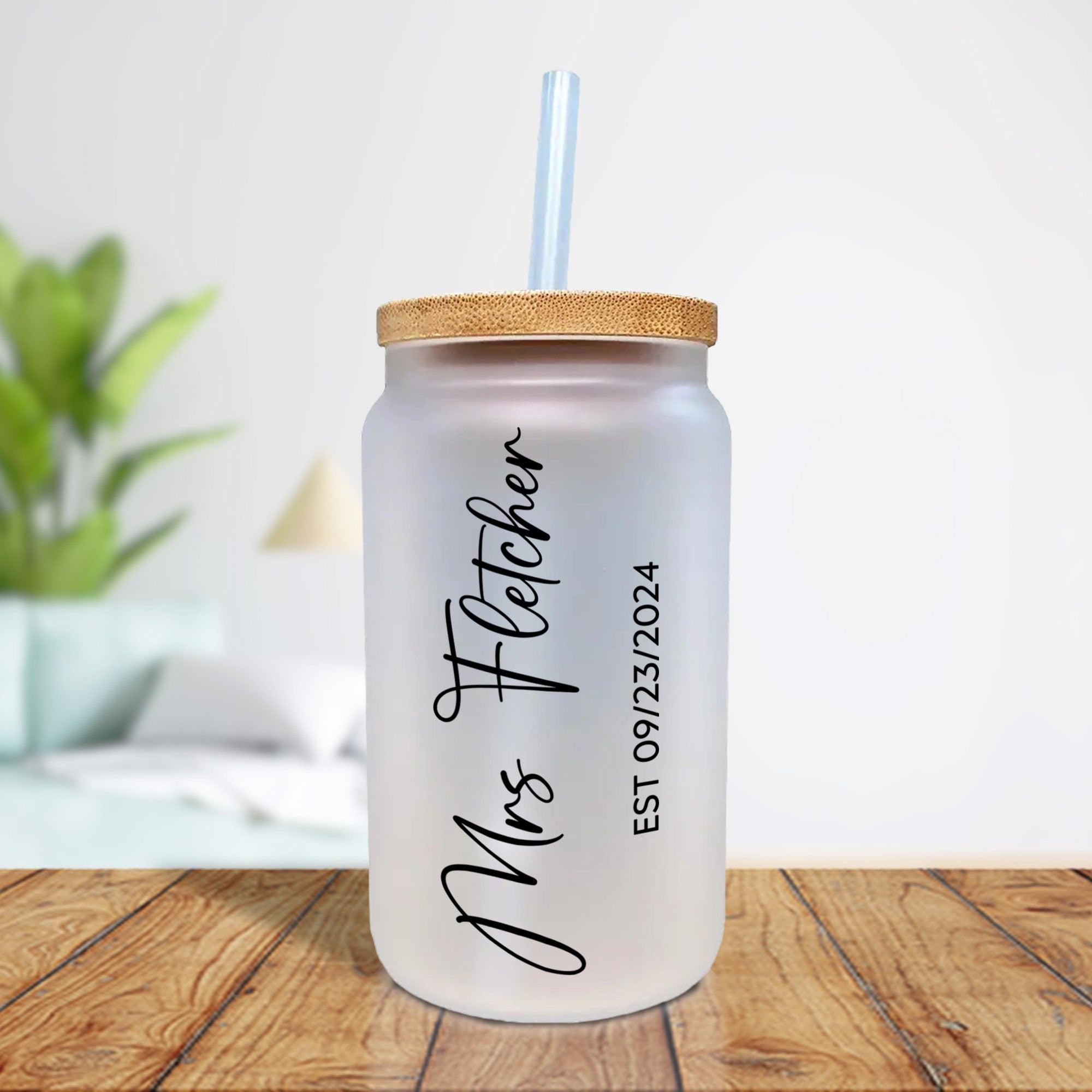a white mason jar with a straw in it on a wooden table