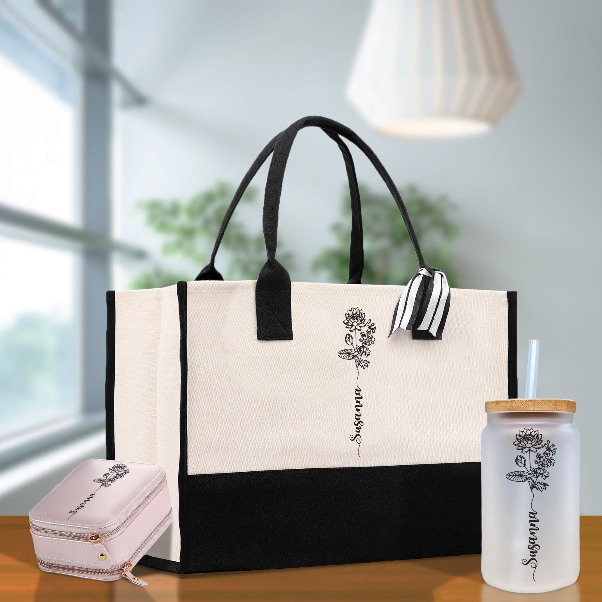 a black and white tote bag next to a bottle of water