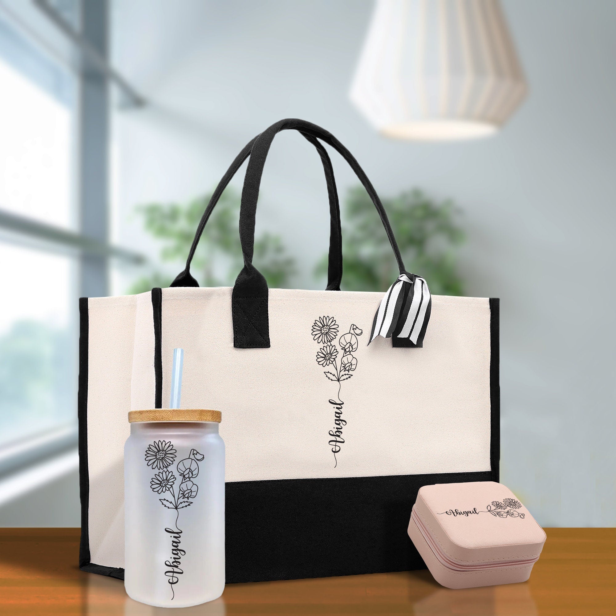 a black and white tote bag, a bottle, and a cup on a